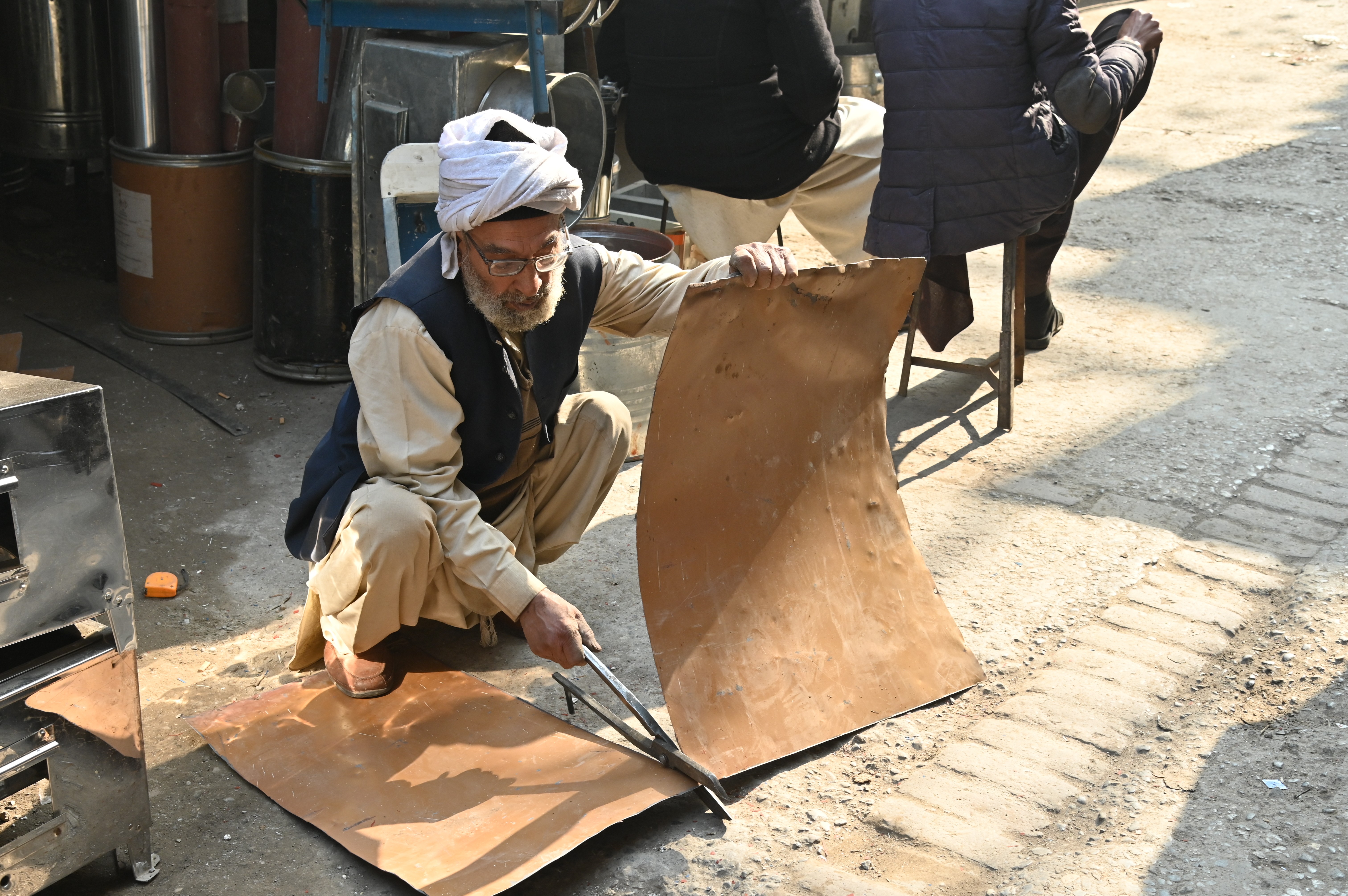A man busy in cutting iron sheets with the cutter