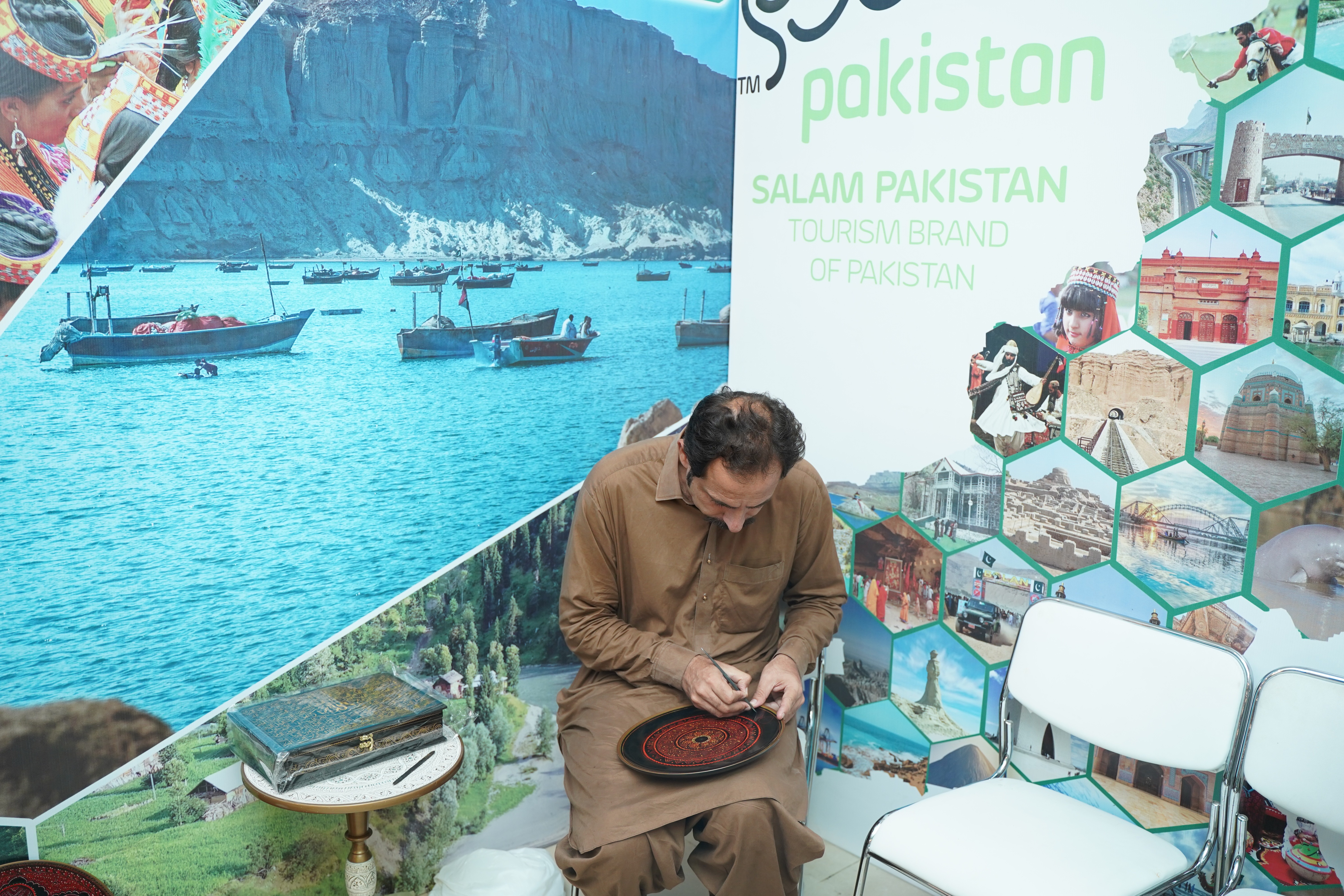 A man busy in making a home décor accessory by encarving on plate using lacquer art