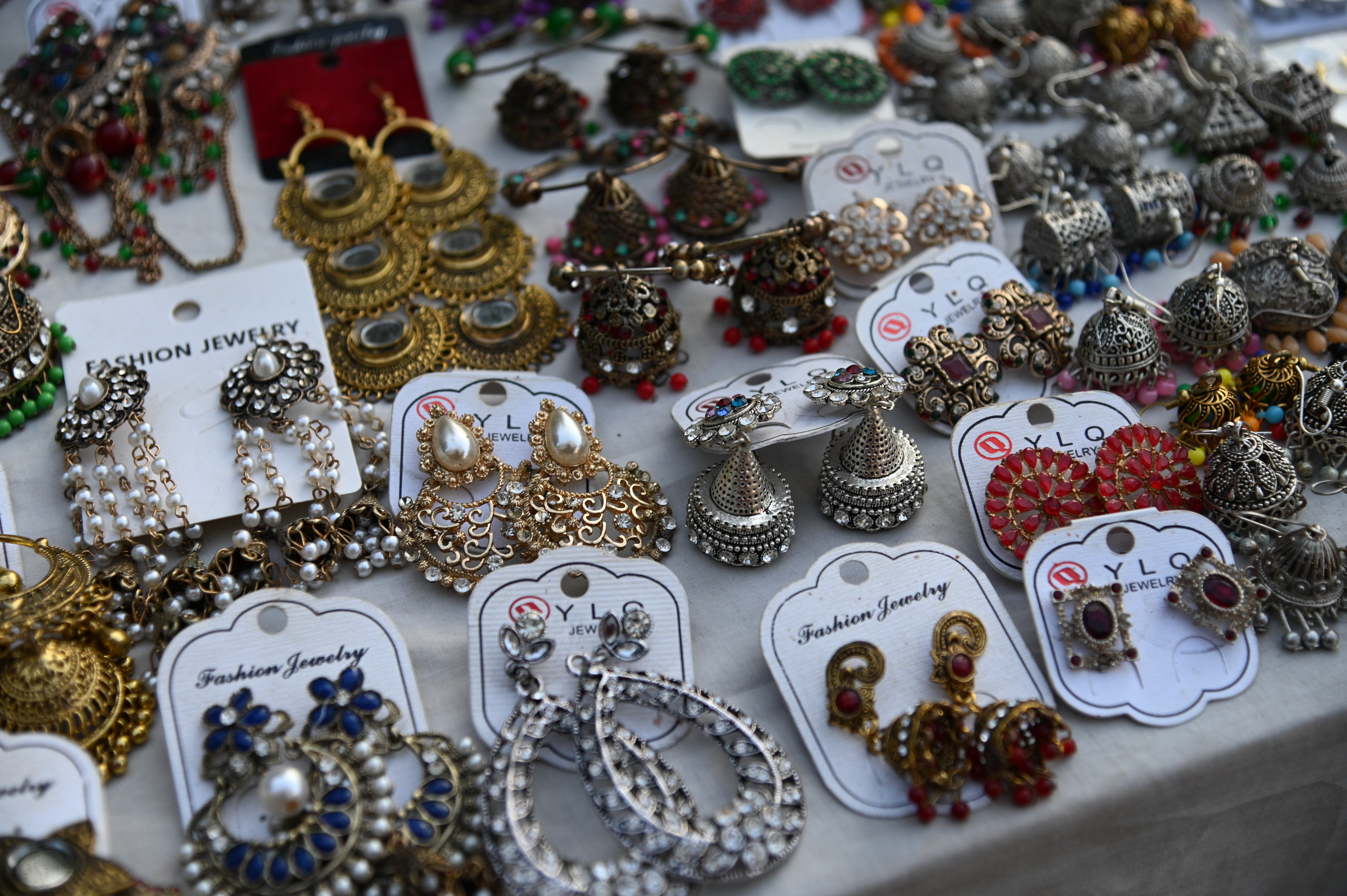 Variety of elegant earrings adorned with pearls and stones.