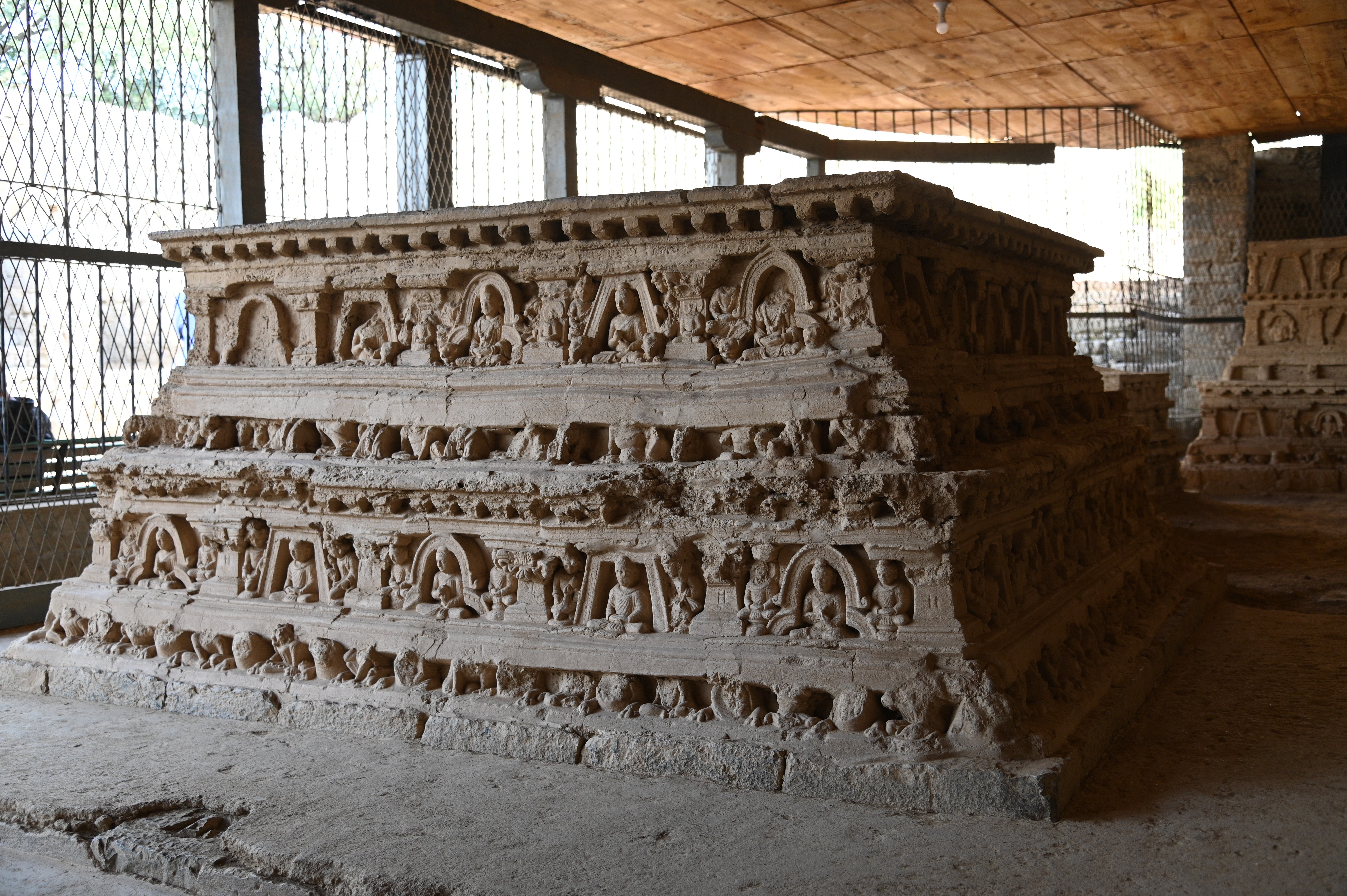 The stupa presents the presence of inscriptions in the Kharoshthi script on the plinths of stupa