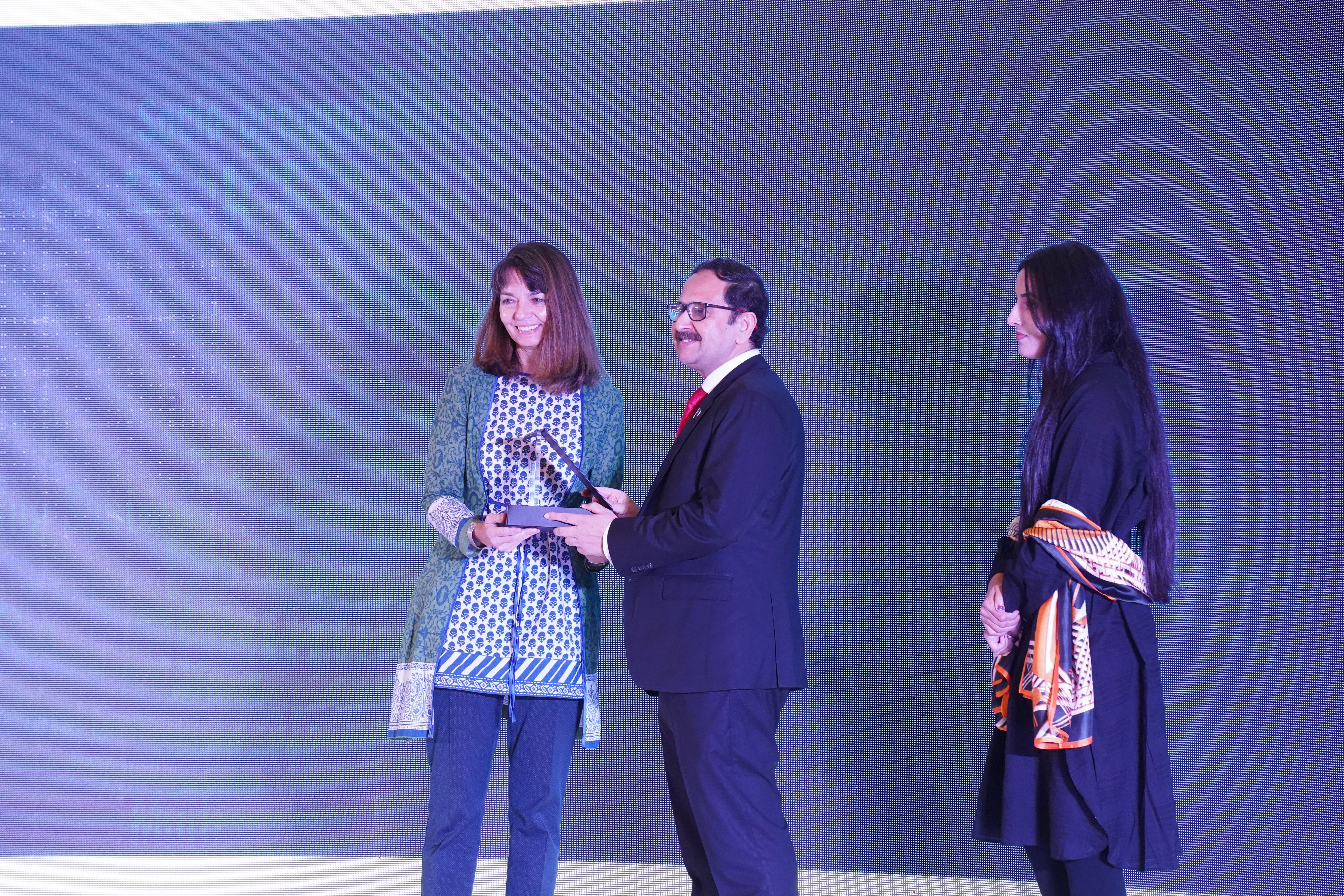 Bilal Anwar distributing awards to the guests at a  conference held on investing in a resilient and adaptive future of Pakistan