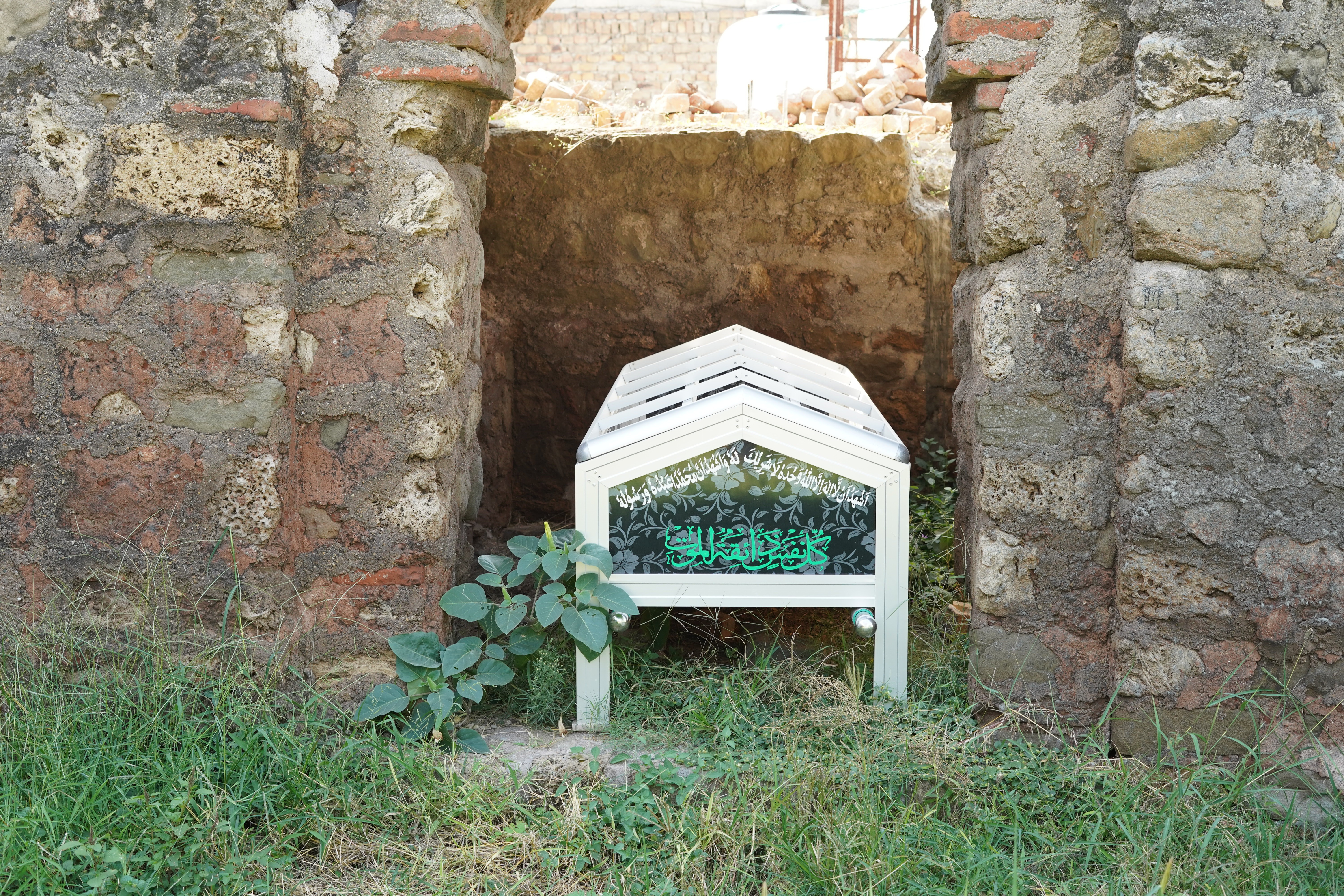 A coffin(a funerary box used for viewing or keeping a corpse, either for burial or cremation)   on which Arabic Verses are written