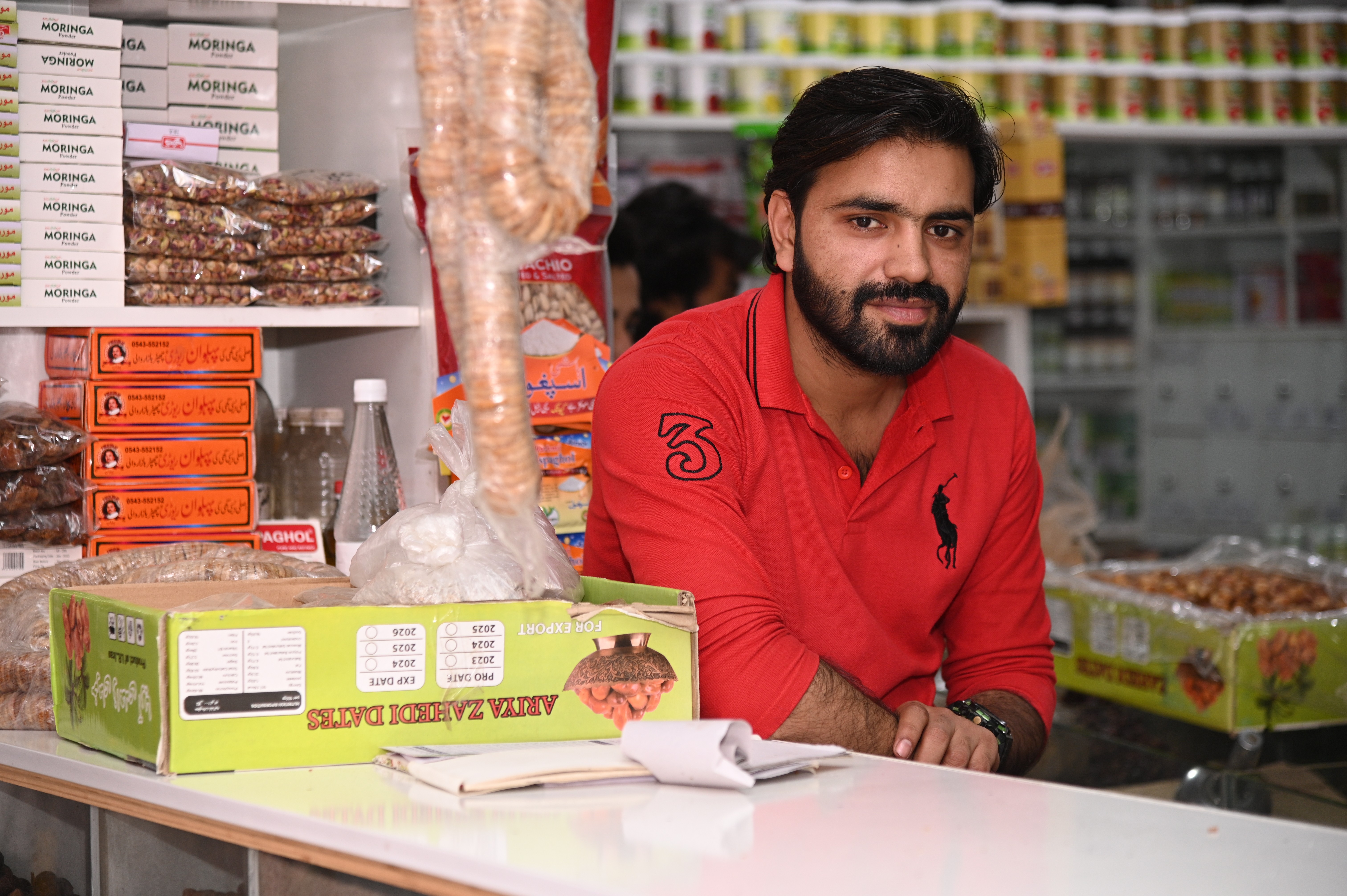 A man selling dryfruits and other household goods at a general store