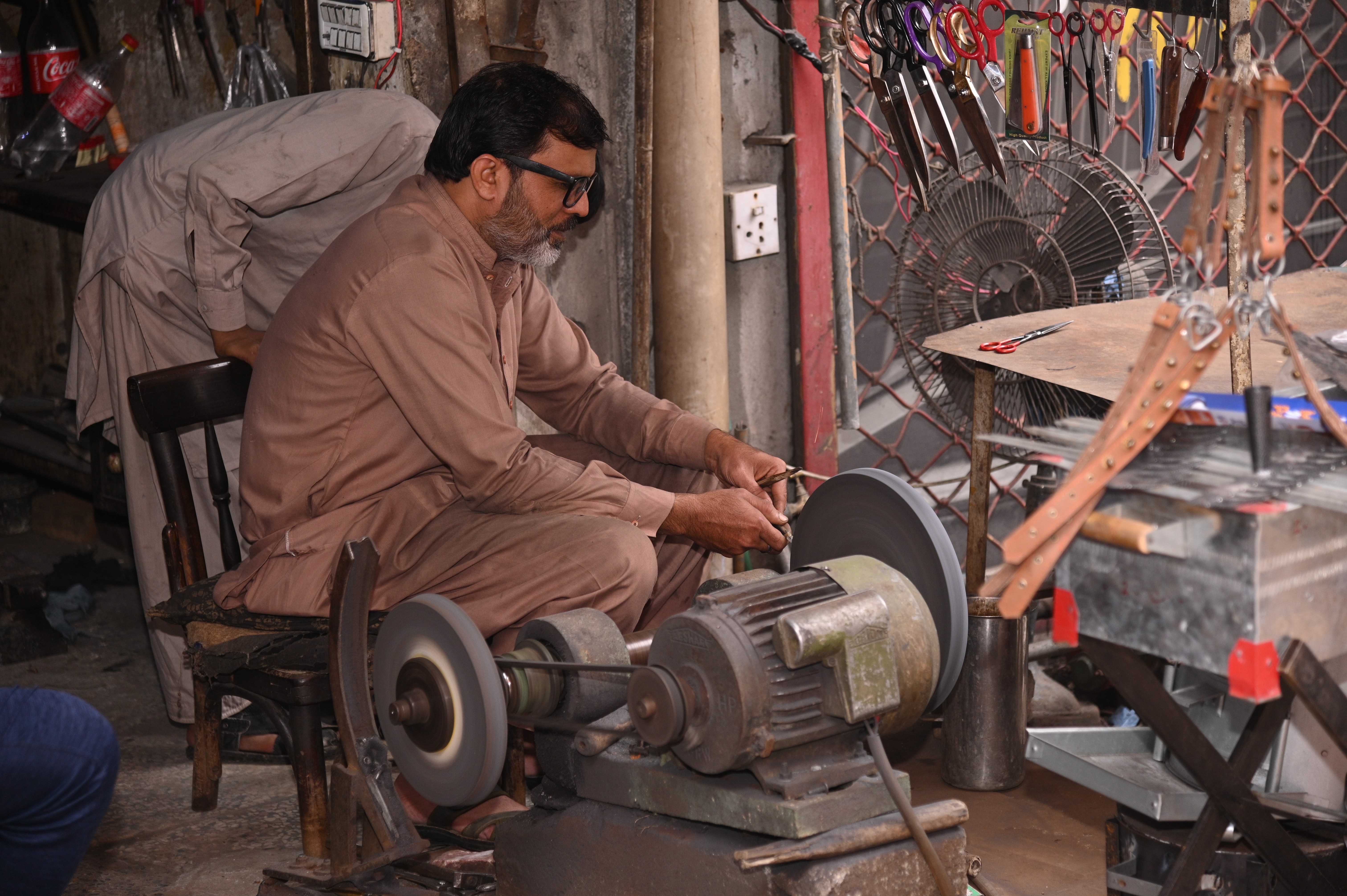 A scissor sharpener busy in sharpening the scissors