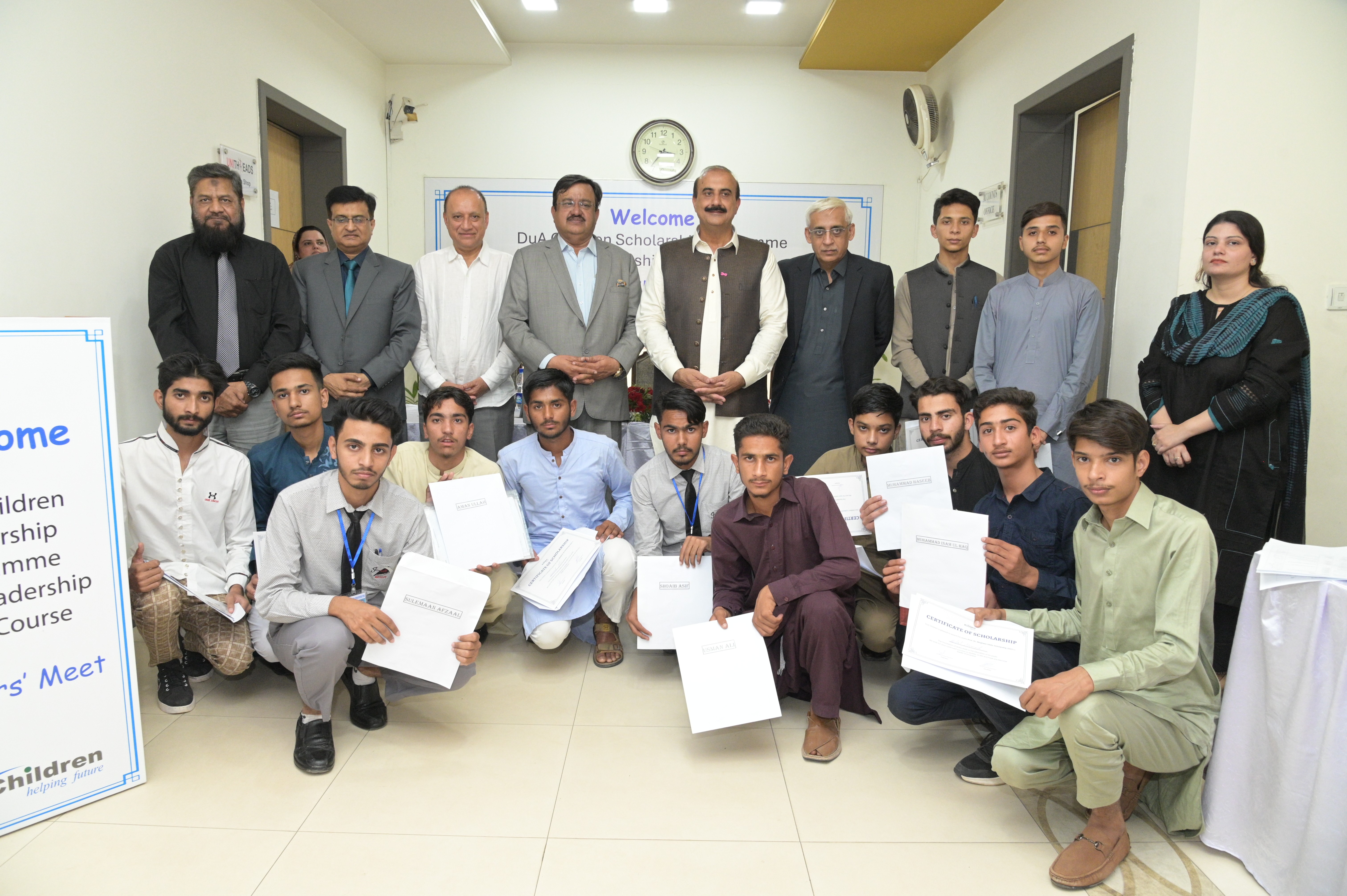 A group photo of scholarship-winning students with the organization leaders and chief guests