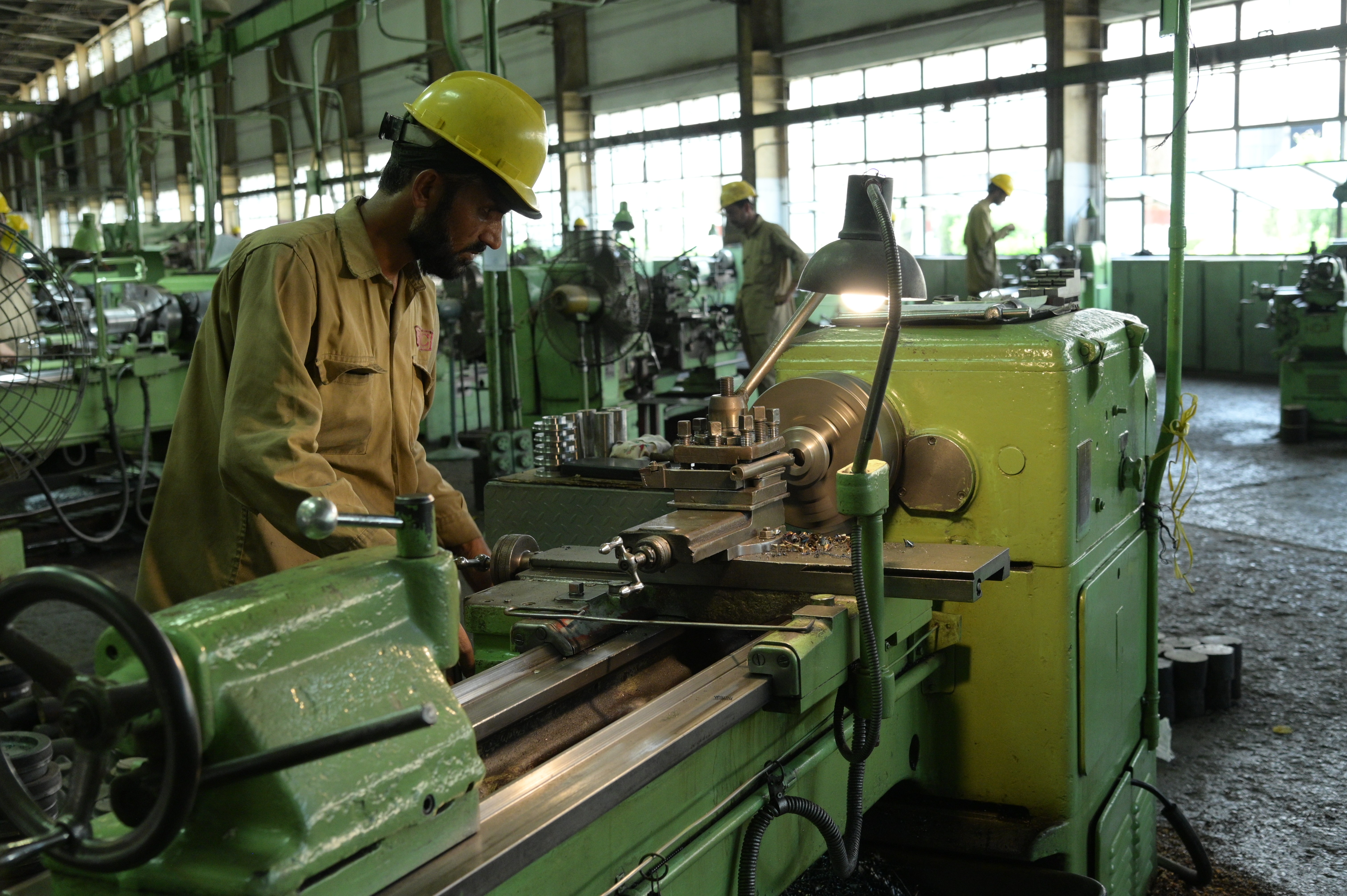 A worker making small iron pipes