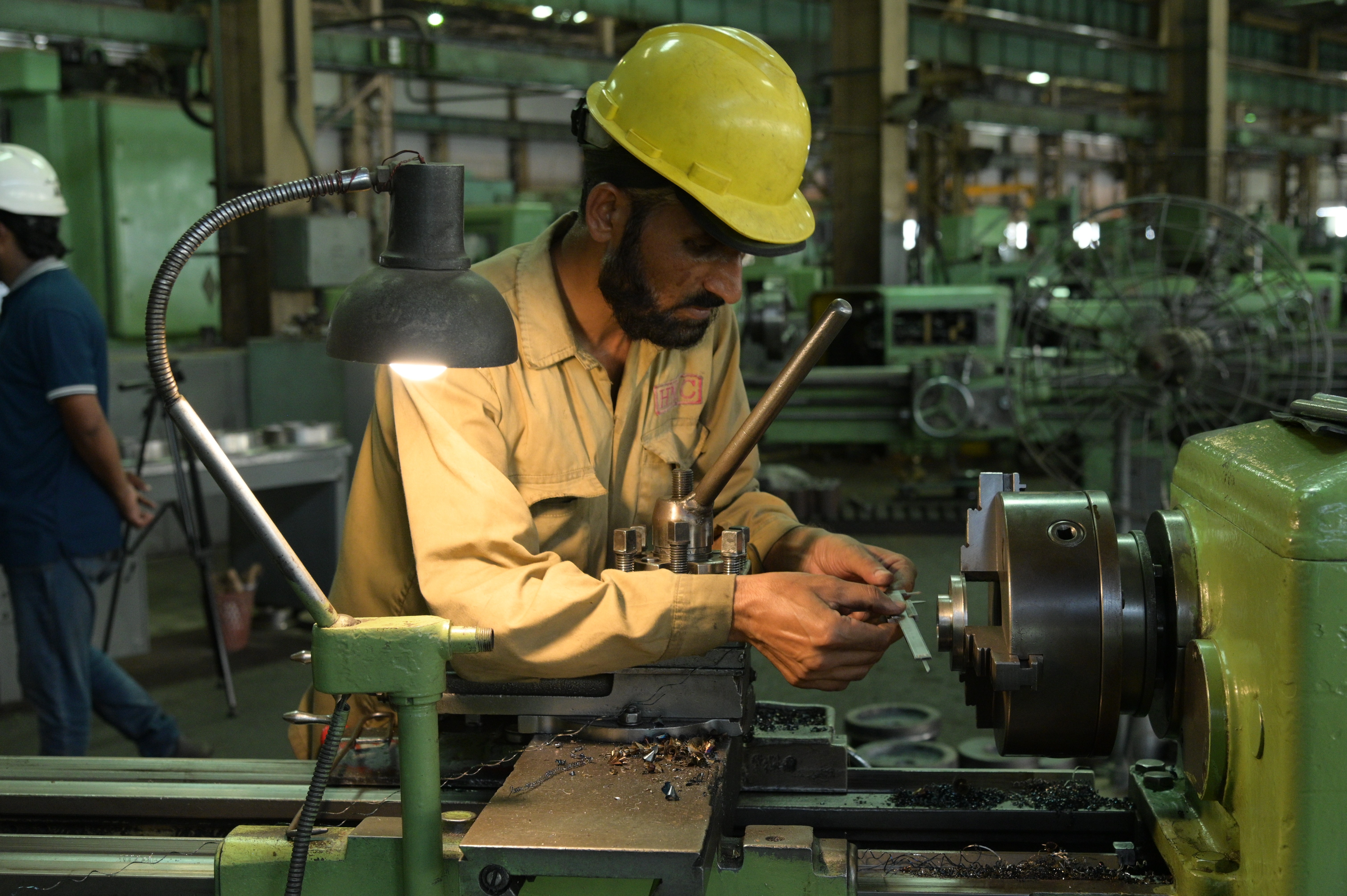 A man using vernier calliper to measure the thickness of pipes