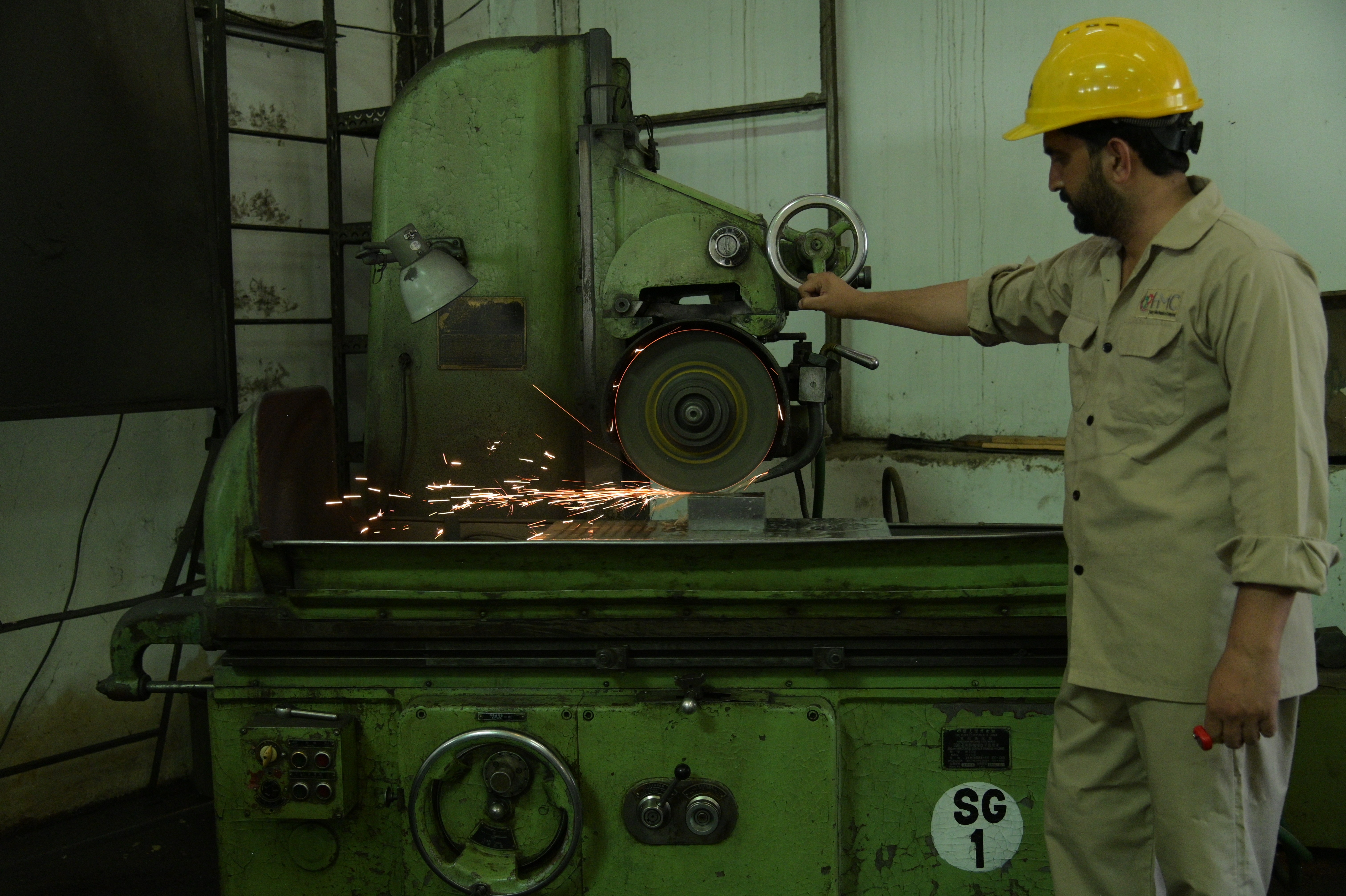 worker using blades to cut the iron cubes