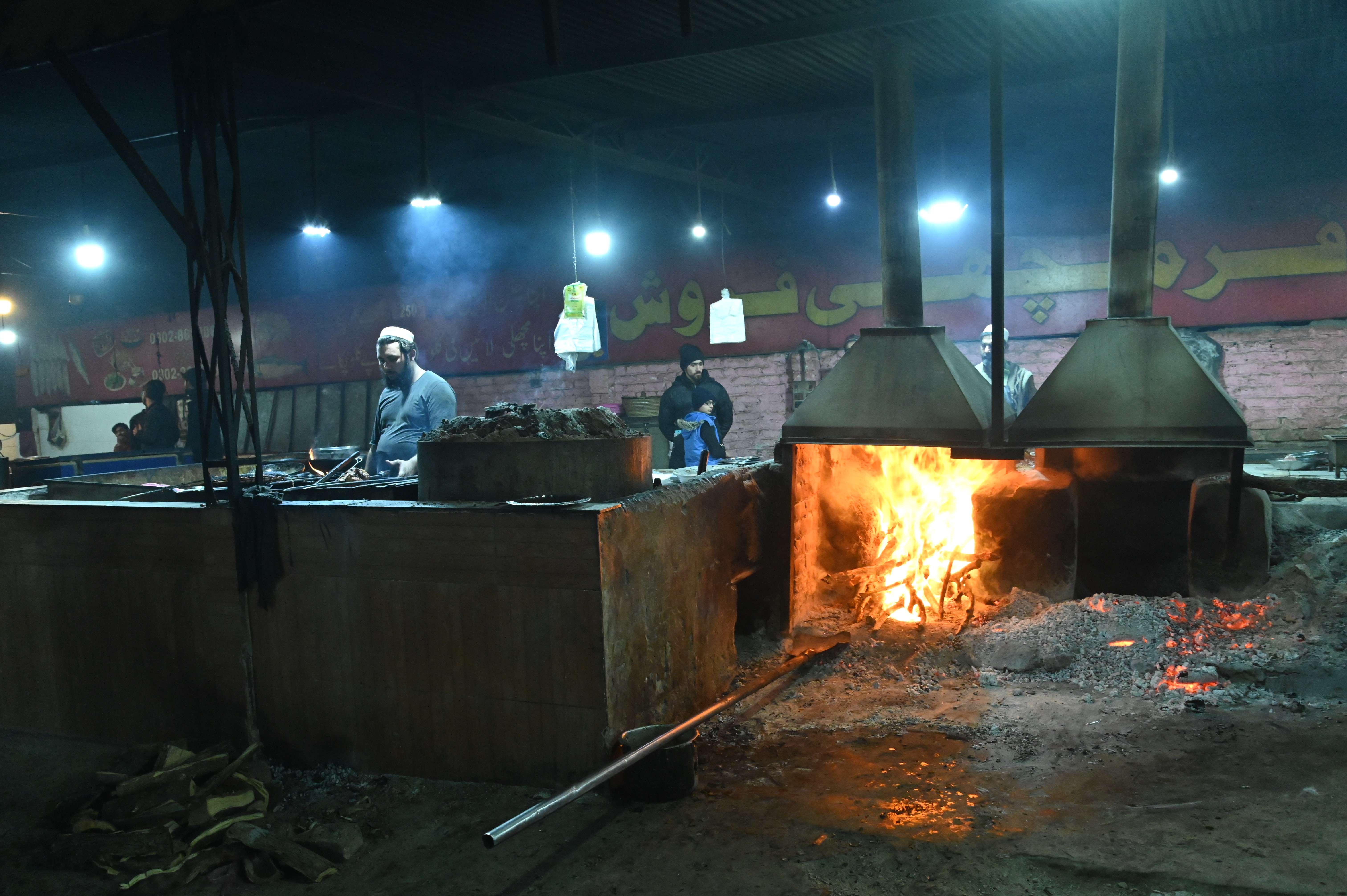 A man in local food restaurant making fish over medium heat coals