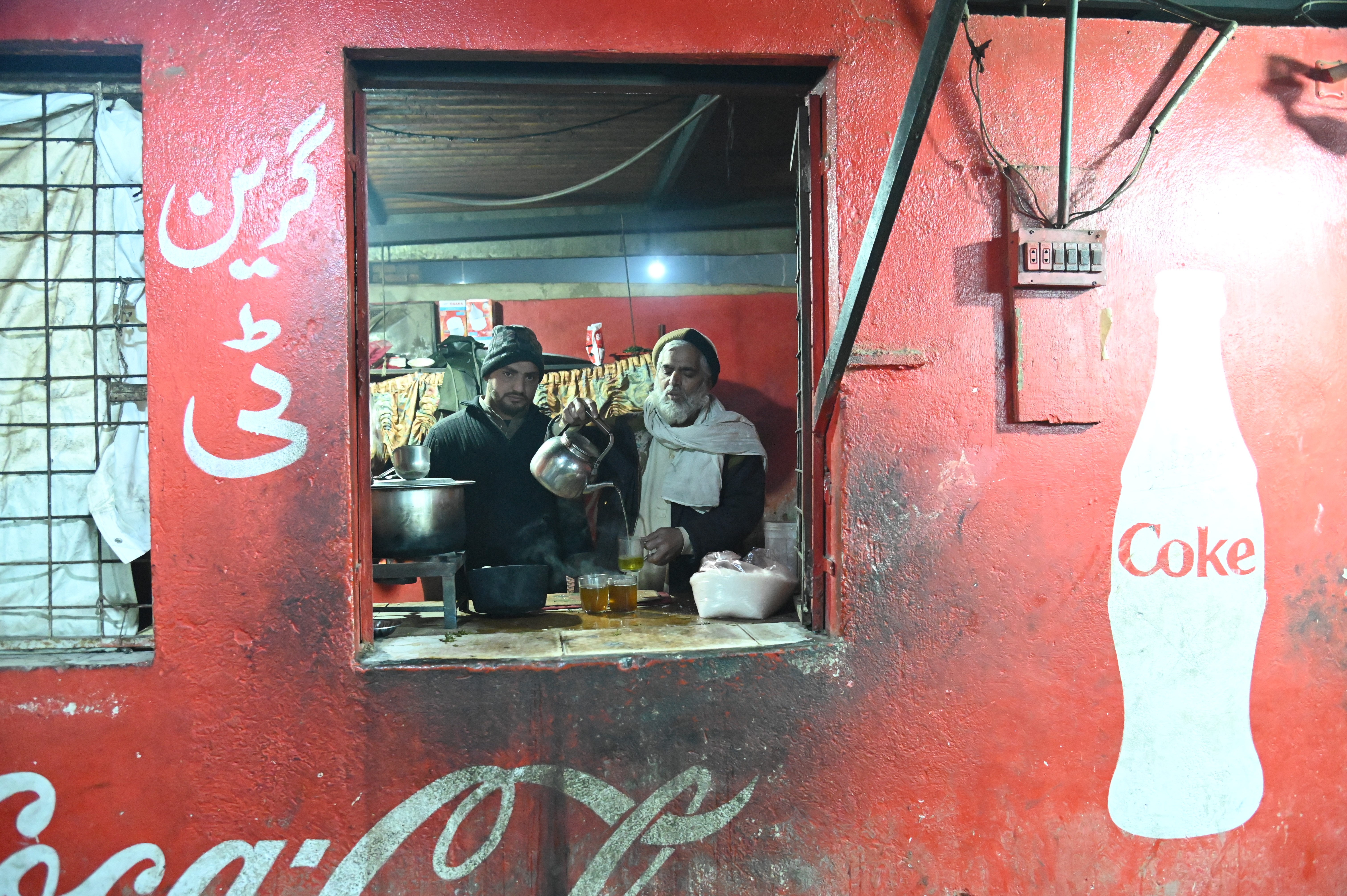 Men busy in serving green tea in a Dhaba, a roadside restaurant
