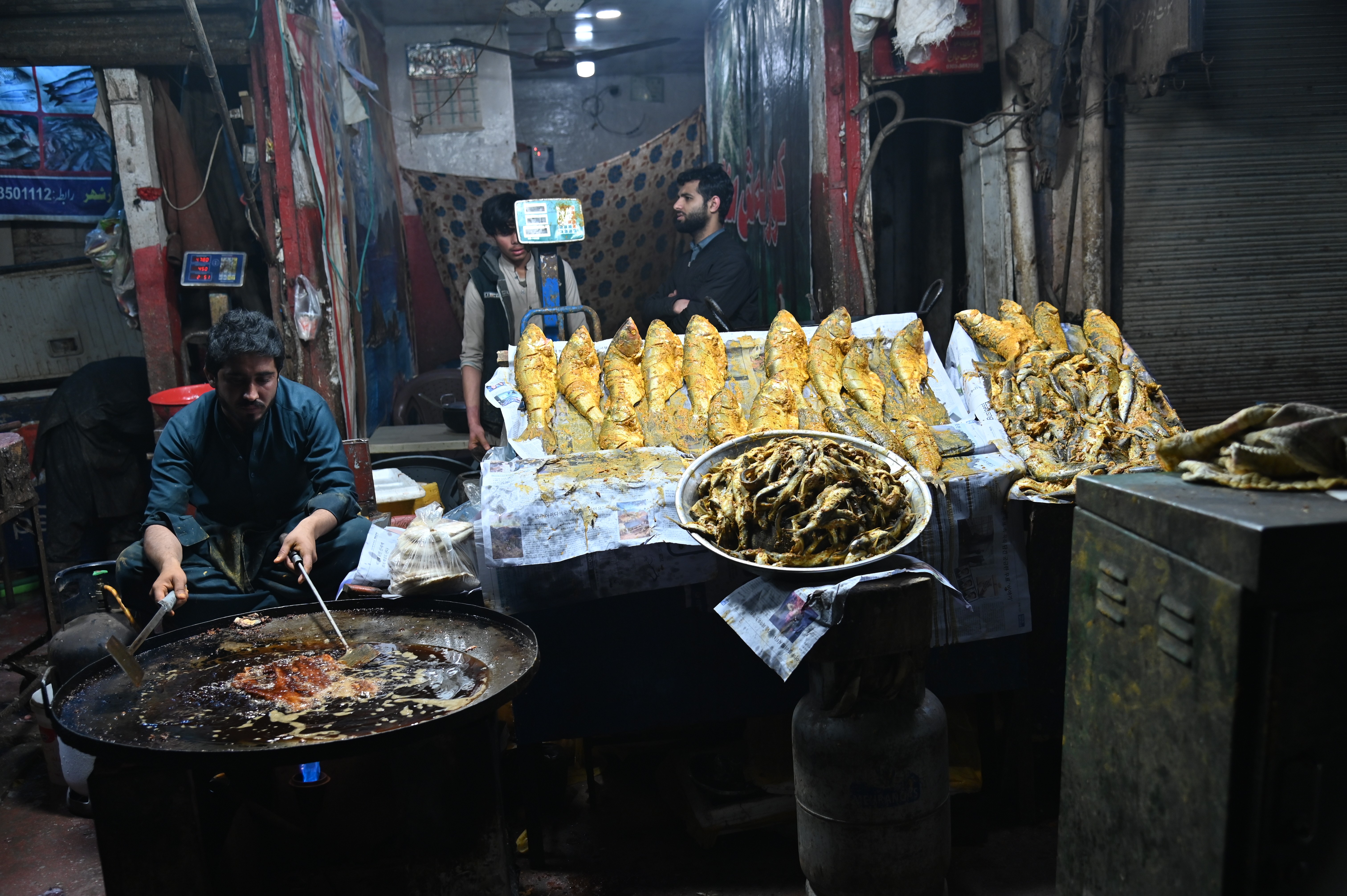 Man selling fried fish in a roadside restaurant