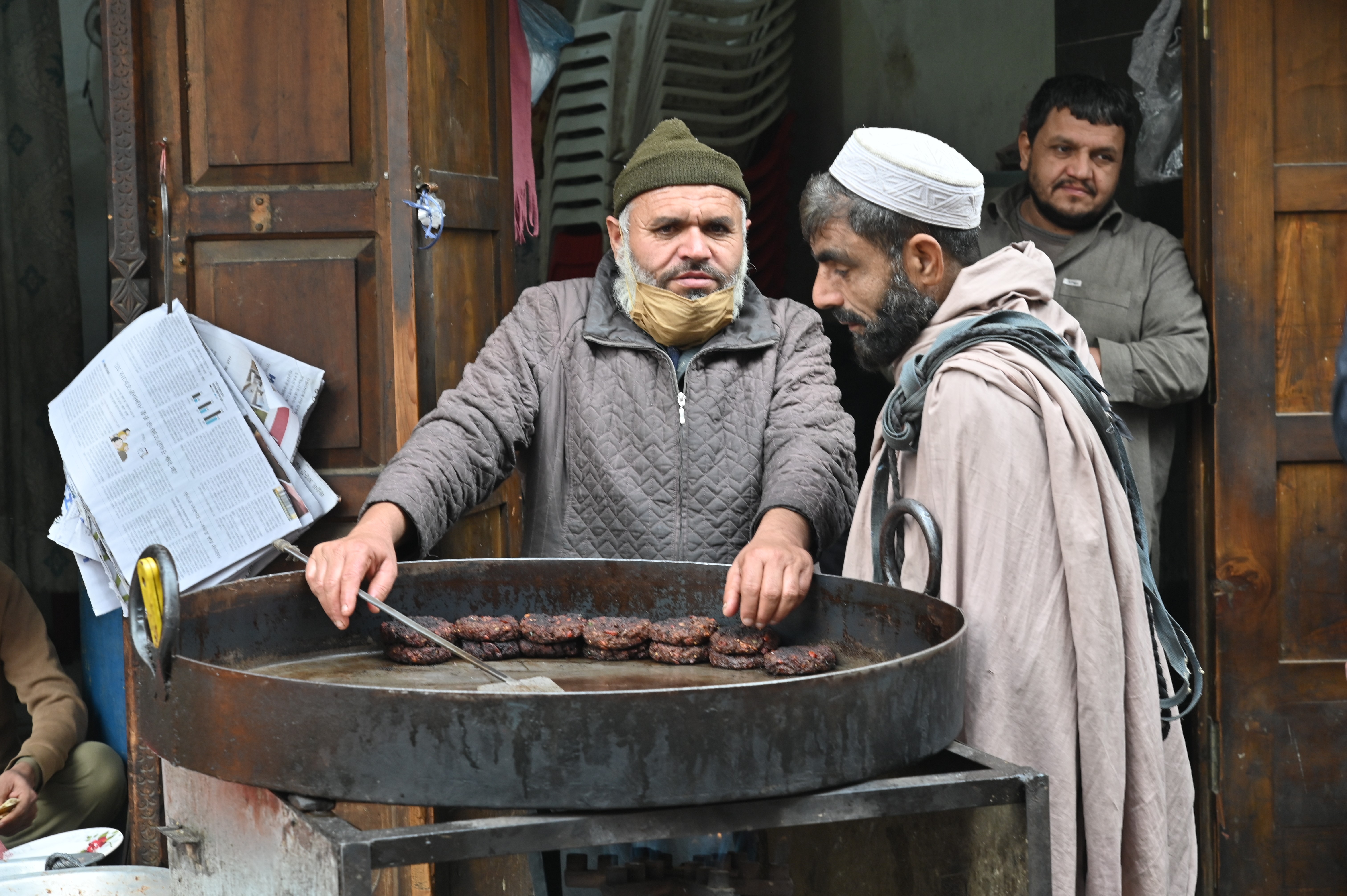 A man selling Chapli Kebab, a Pashtun-style minced kebab, usually made from ground beef, mutton or chicken with various spices in the shape of a patty