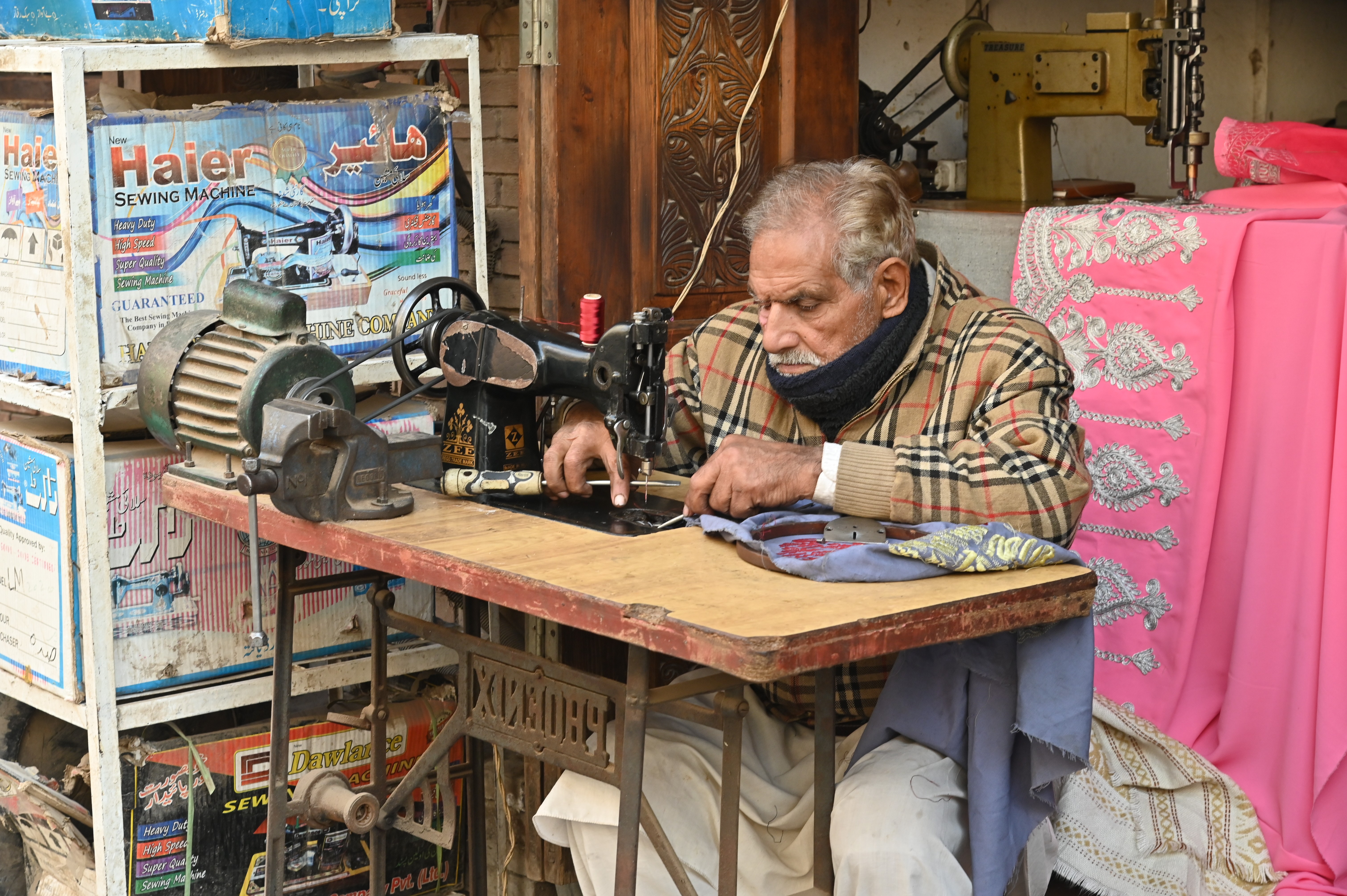 A man busy in stitching the cloths