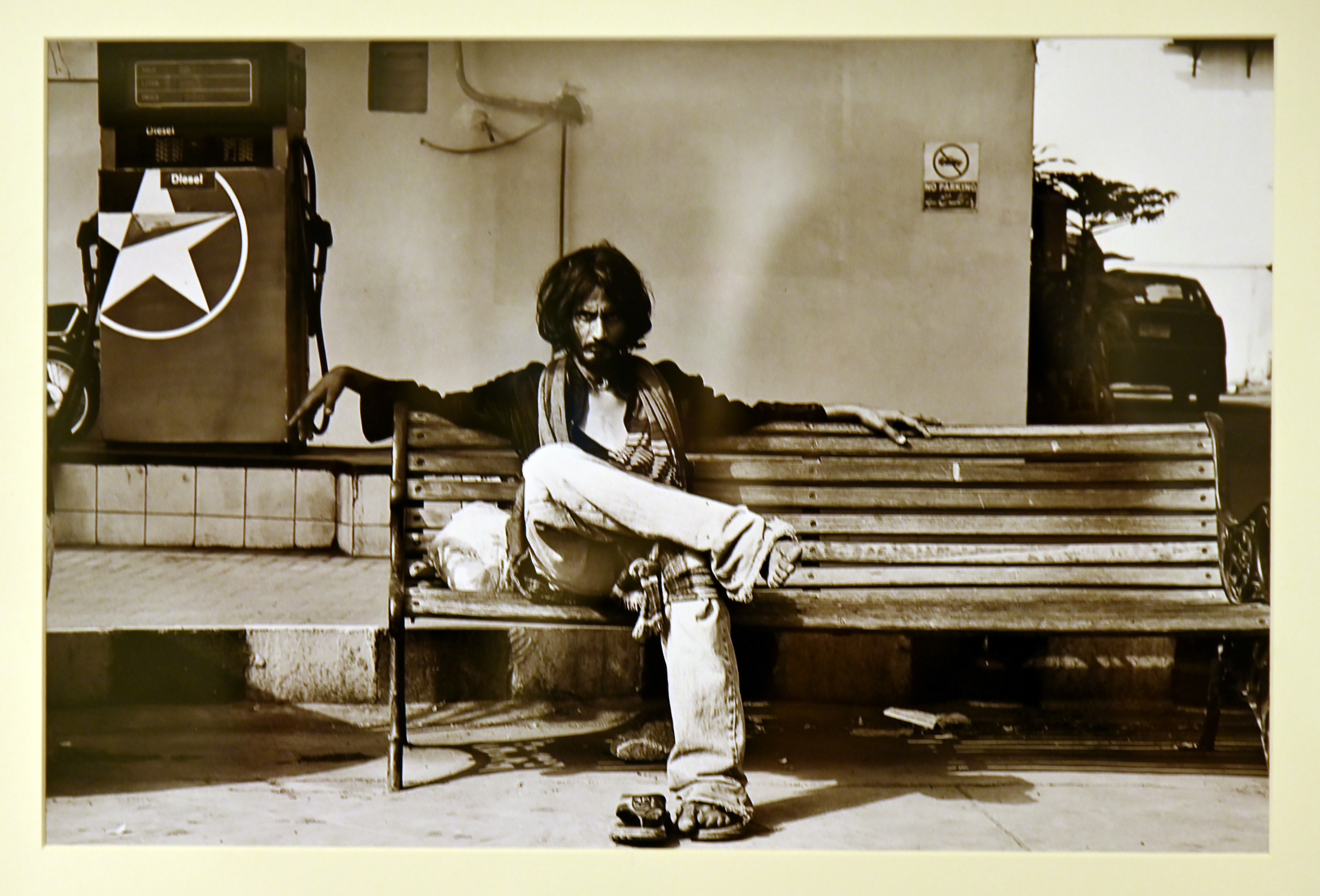 A man sitting on a bench near a petrolpump