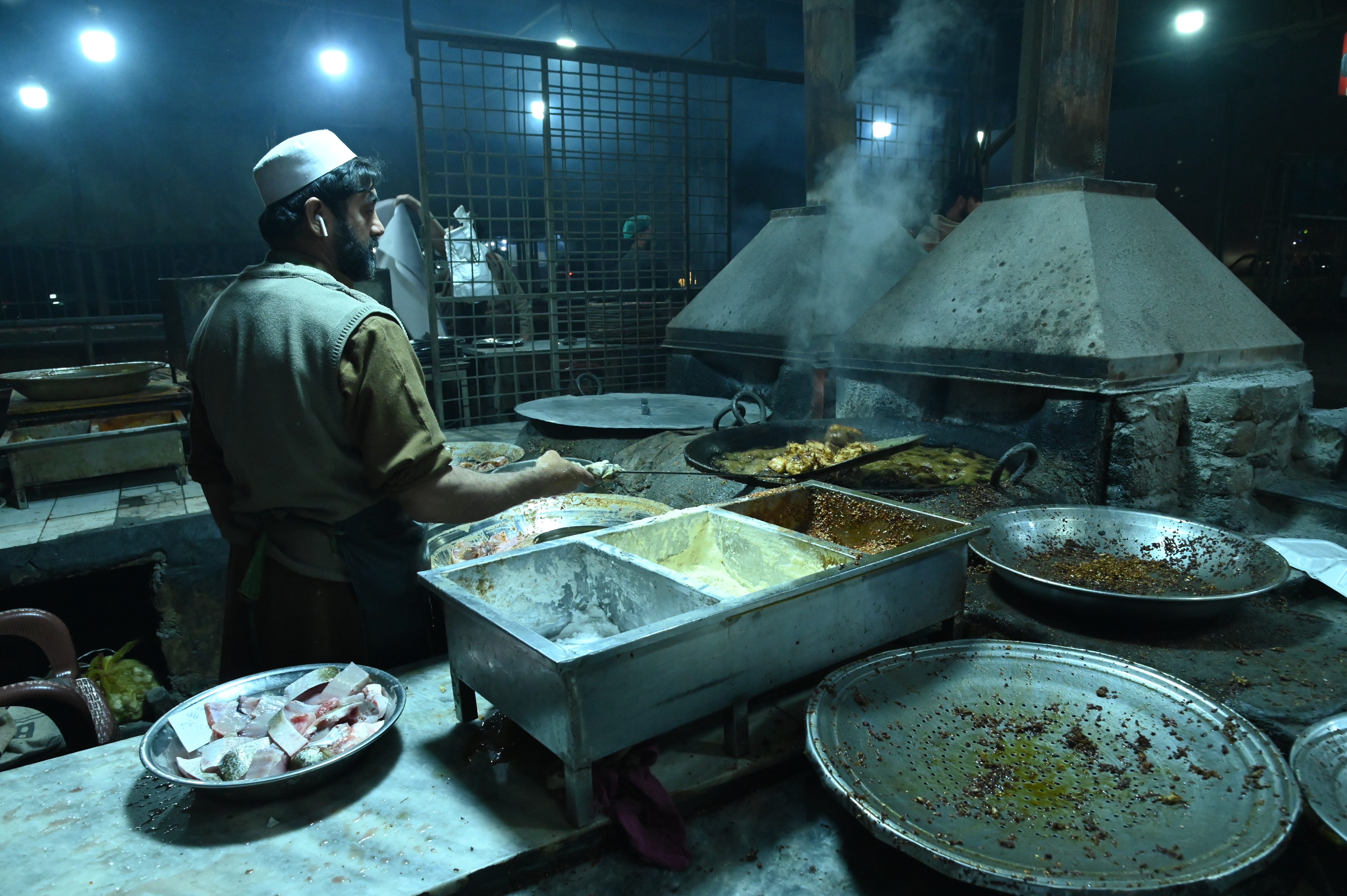 A man making fried fish in the food street