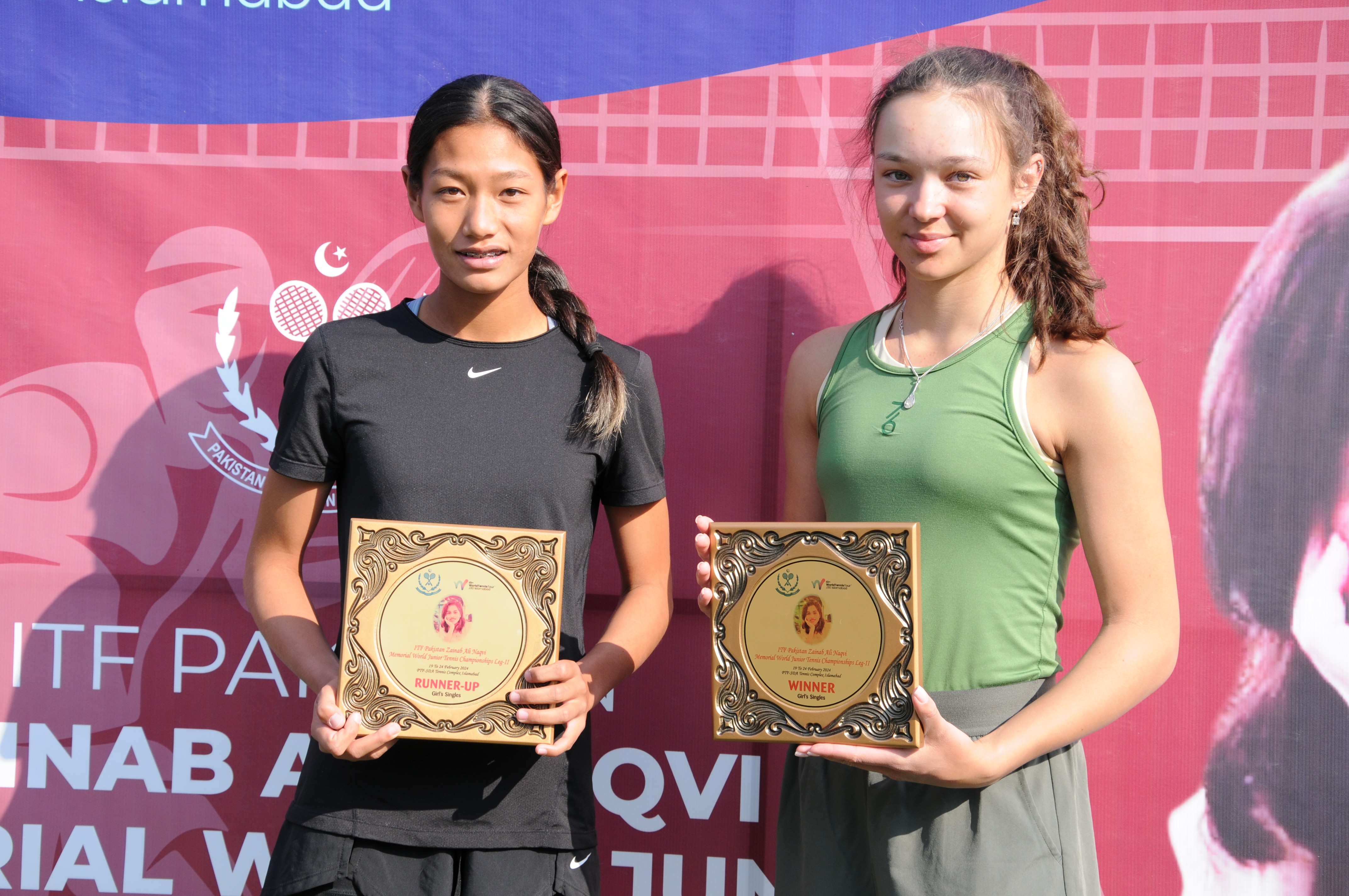 Tennis players posing with their winning trophy