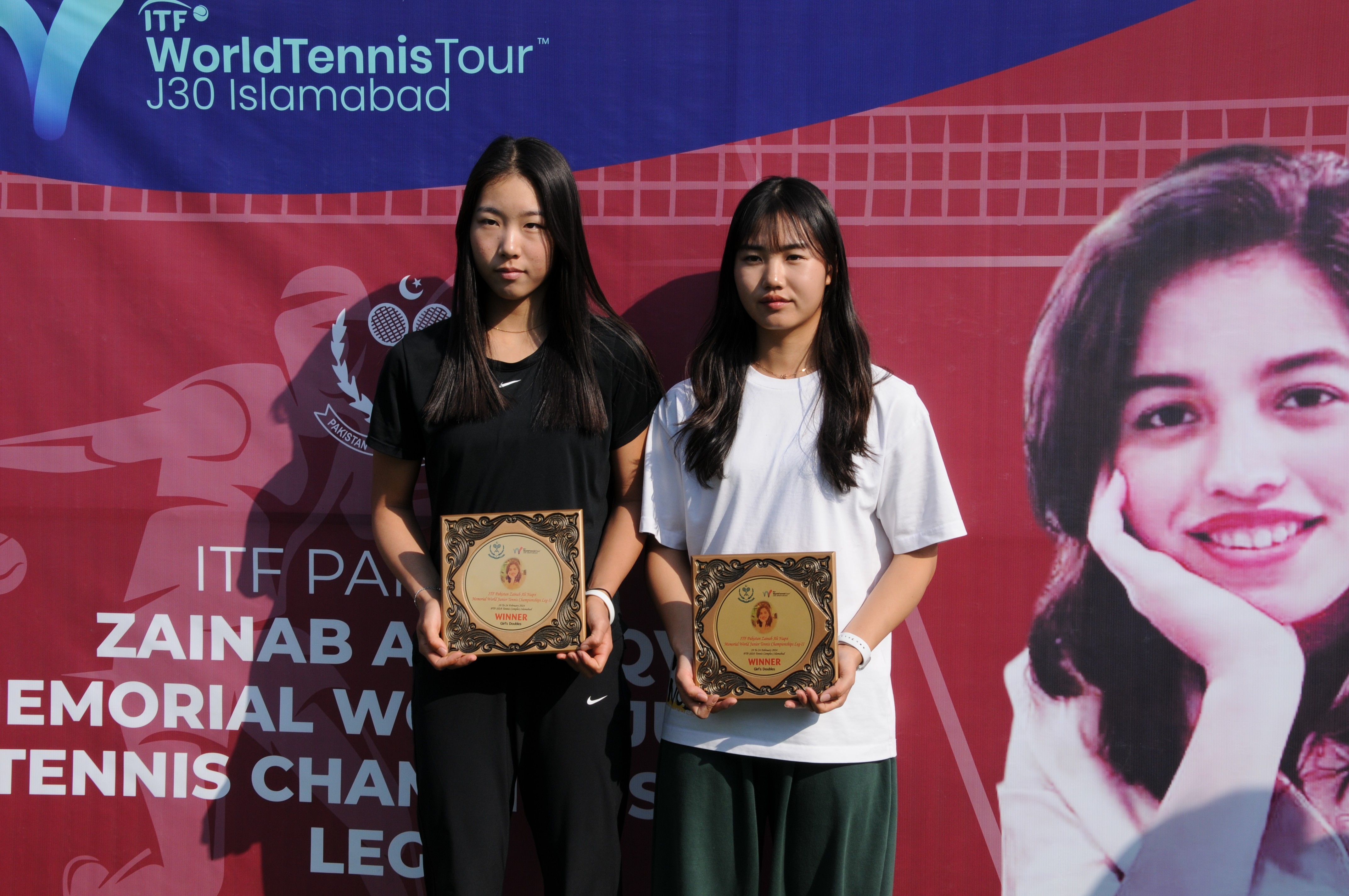 Tennis players posing with their winning trophy