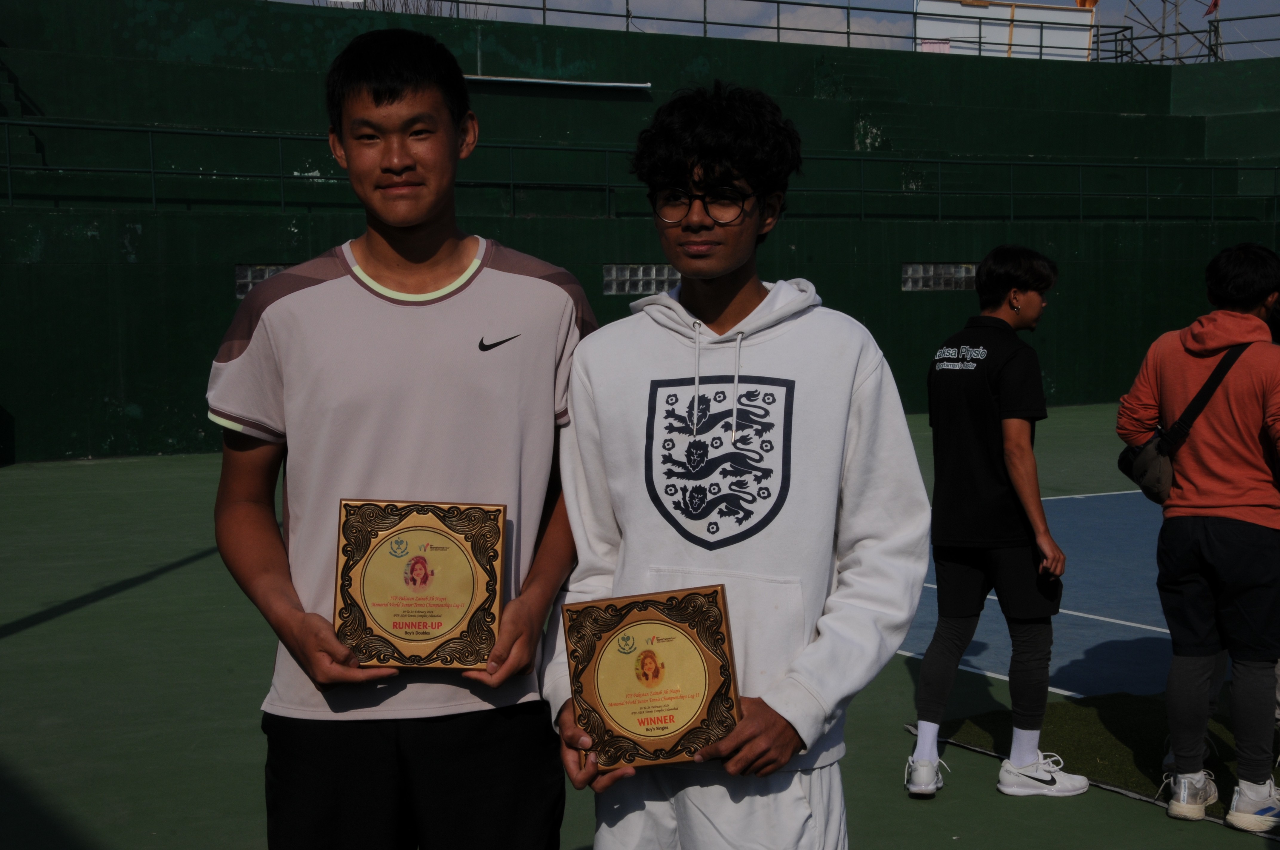 Tennis players posing with their winning trophy