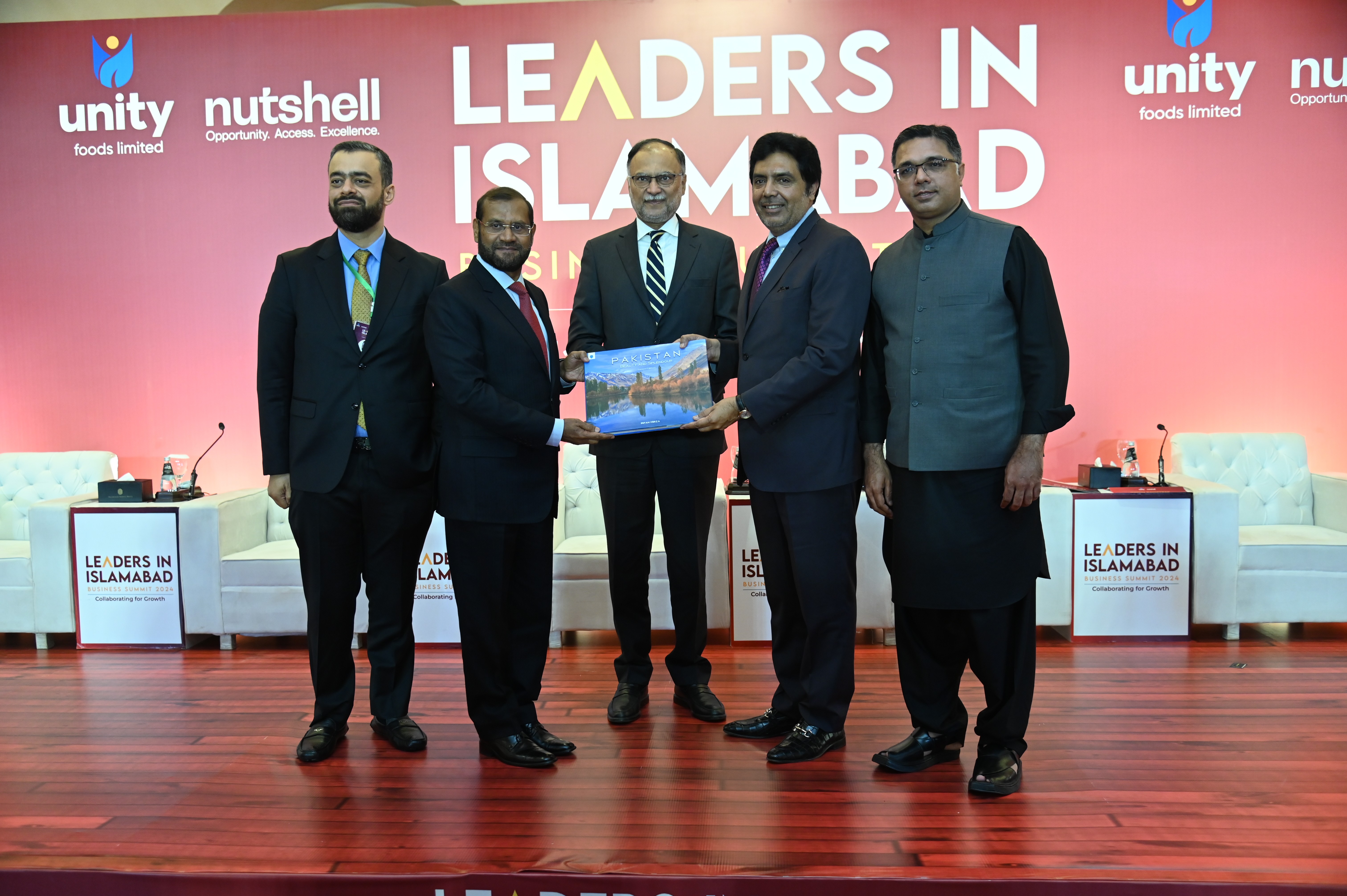 The delegates posing with the handbook of Pakistan at the Business Summit 2024