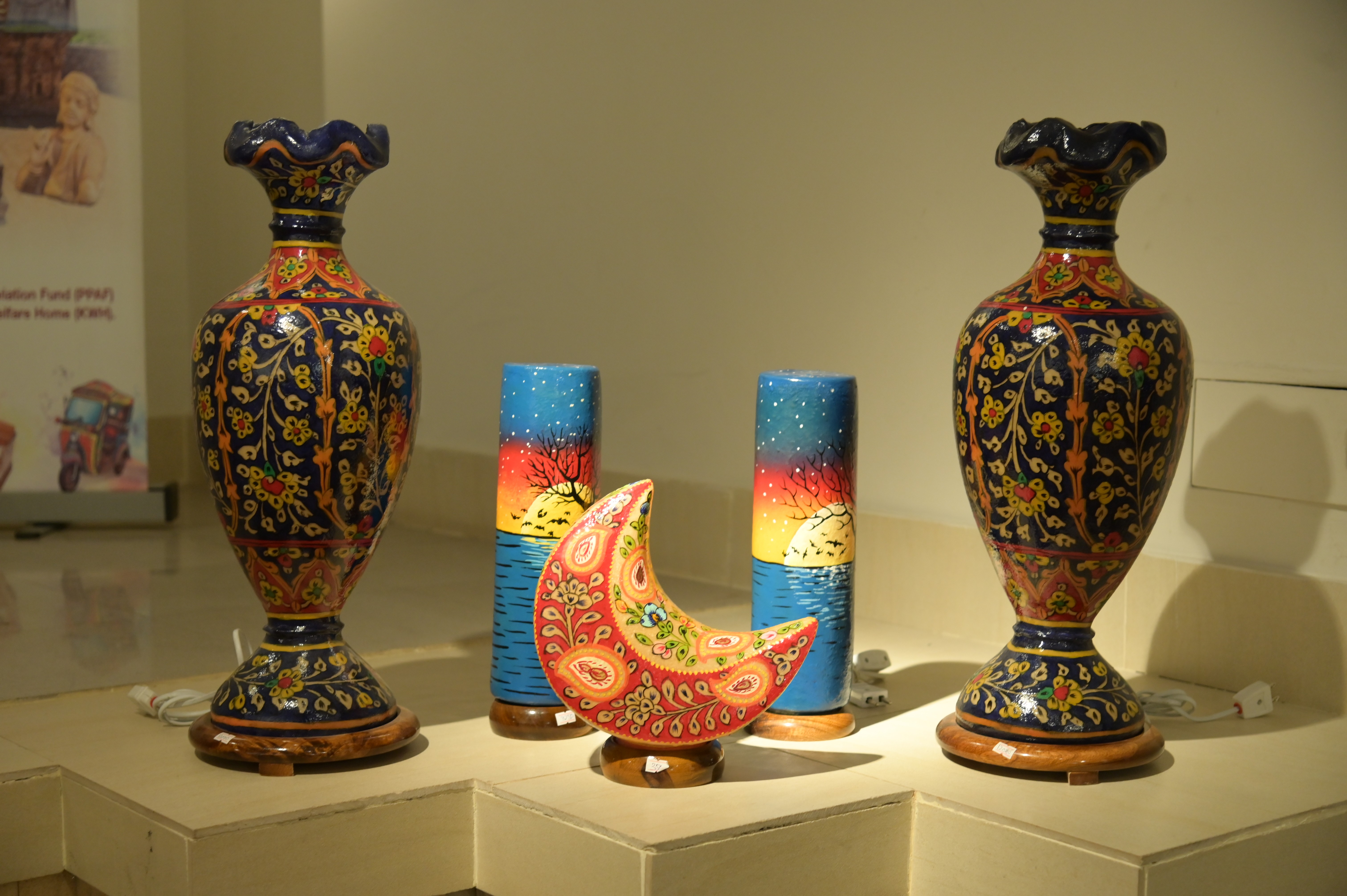 A crescent-shaped decorative piece and hand-painted traditional vase with intricate floral patterns