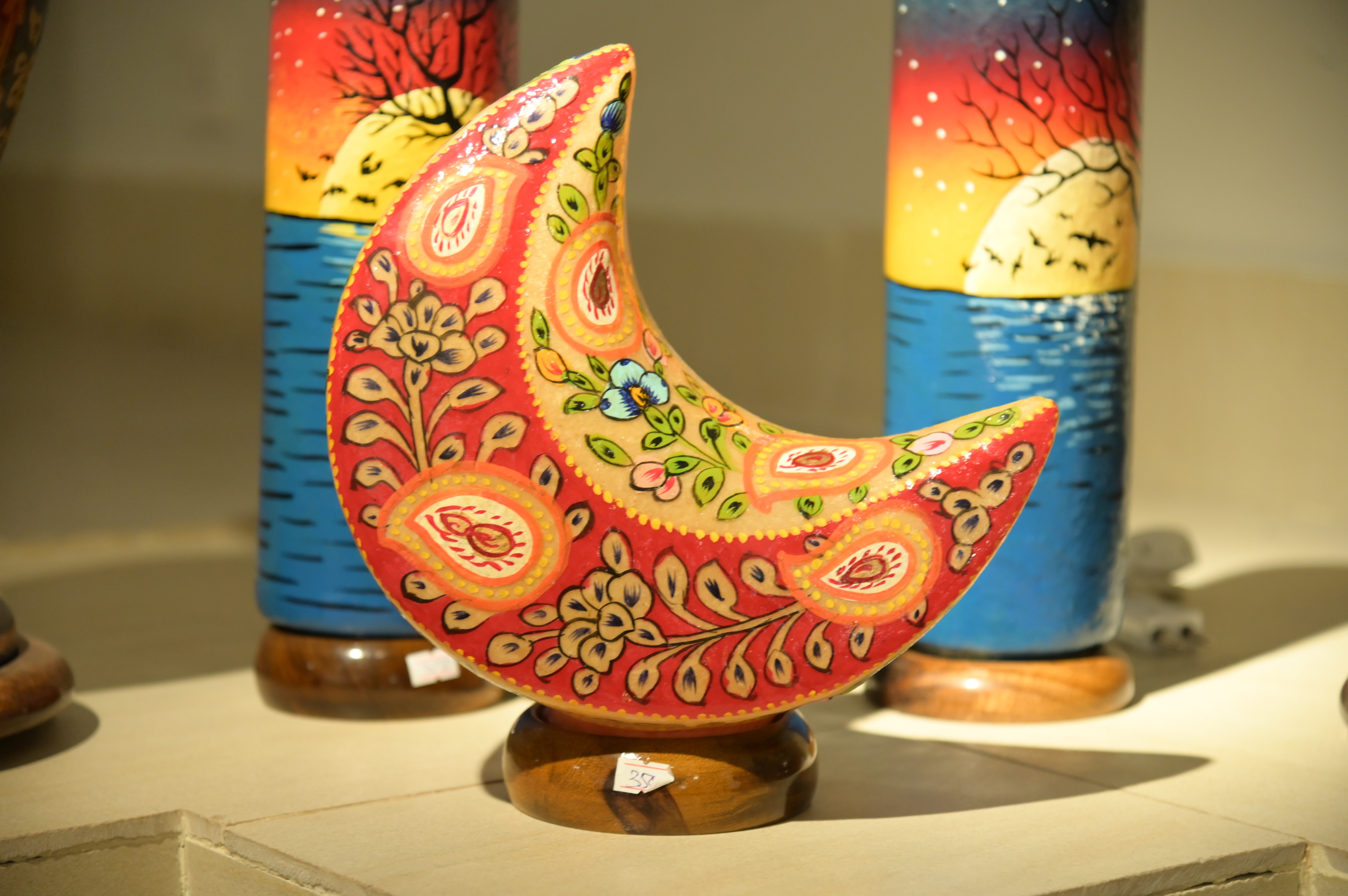 A crescent-shaped decorative piece with vibrant floral patterns