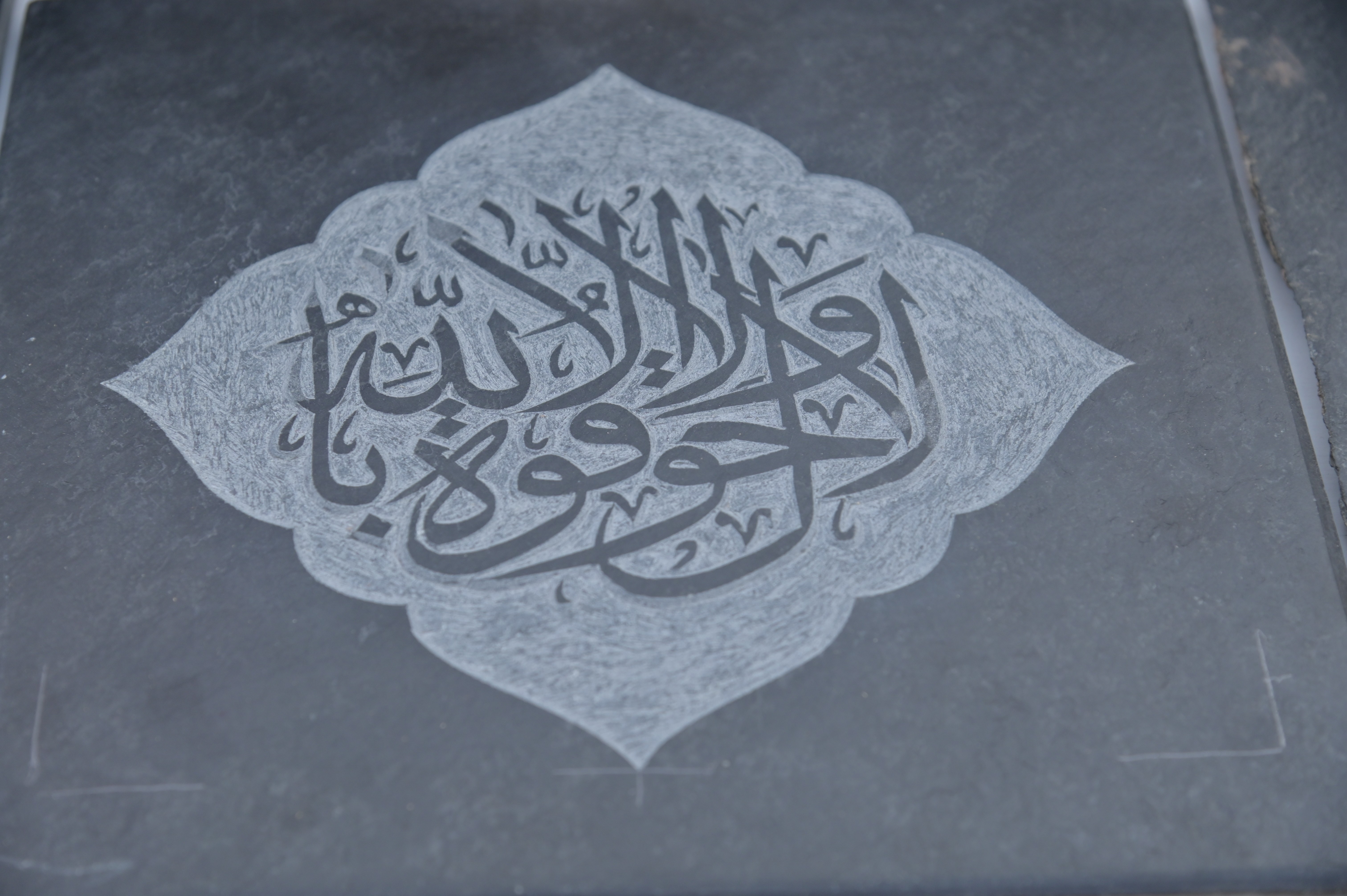 Intricate Arabic calligraphy engraved on a stone slab
