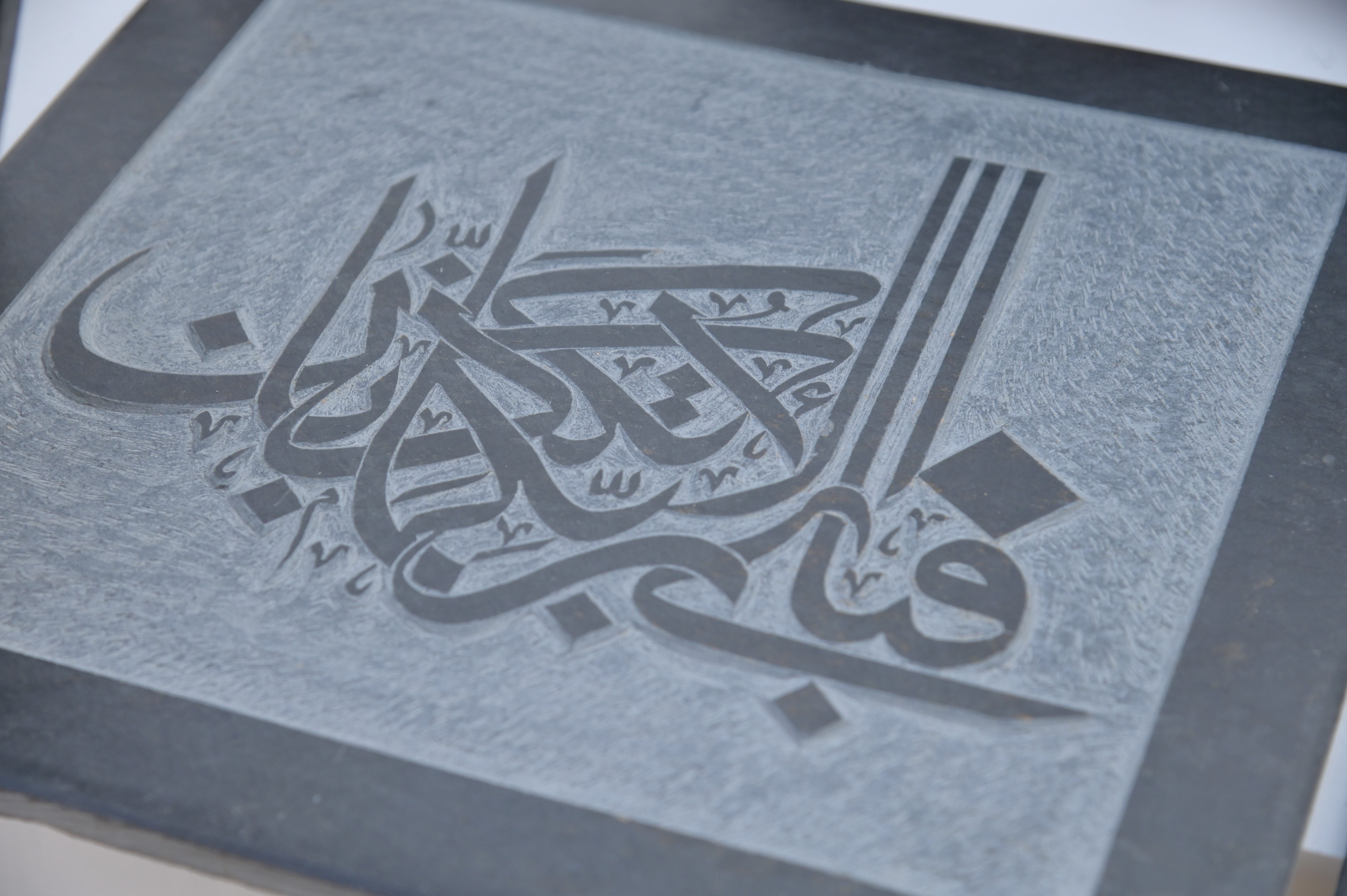 Intricate Arabic calligraphy engraved on a stone slab
