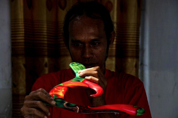 A worker makes an airbrush boomerang craft at his workshop in Bendungan village, Sragen district, Central Java, Indonesia, Aug. 22, 2022. (Photo by Bram Selo/Xinhua)